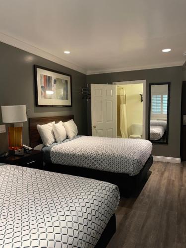 a bedroom with two beds and a mirror at La Casa Inn in Pasadena