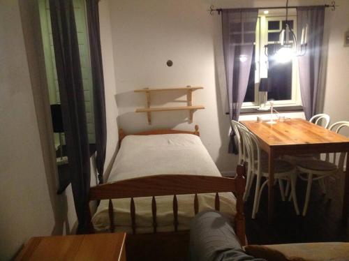 Cette chambre comprend un lit, une table et une fenêtre. dans l'établissement Mysig liten stuga i Vemdalen, à Vemdalen
