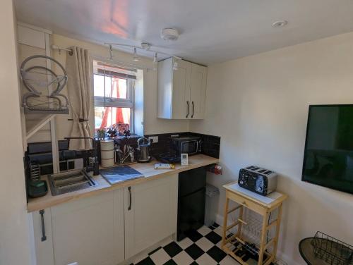 a small kitchen with a counter and a microwave at Flemingate Cottage, Beverley in Beverley