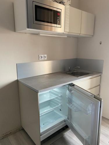 an empty kitchen with a sink and a microwave at Appart'Hôtel Sous Les Pins in Martigues