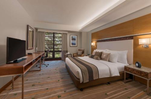 a bedroom with a bed and a desk and a television at Best Western Plus The Ivywall Hotel - Palawan in Puerto Princesa City