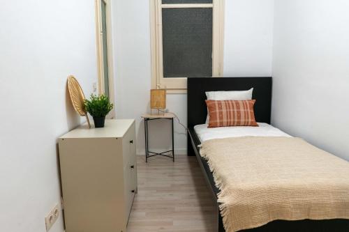 ein kleines Schlafzimmer mit einem Bett und einem Fenster in der Unterkunft Orange crush Barcelona in Barcelona