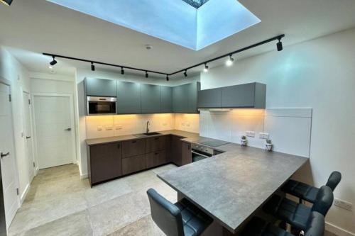 a kitchen with a large island in the middle at Stadium View, 4 Bed 4 Ensuite Bathroom house in Huddersfield