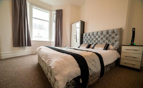 una camera da letto con un grande letto con una grande finestra di Entire 2 Bedroom Ground Floor Apartment - With Parking - Cardiff City Centre a Cardiff
