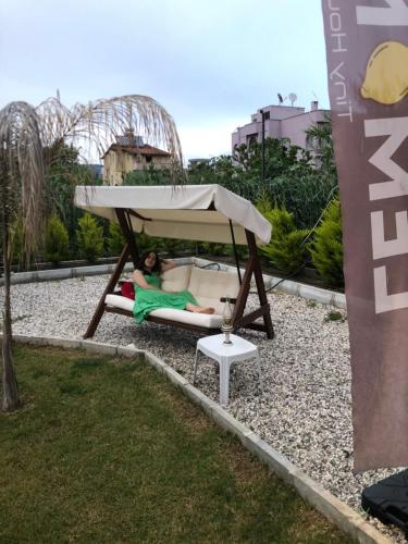 Eine Frau, die auf einer Couch unter einem Pavillon liegt. in der Unterkunft Lemon Tiny House in Antalya