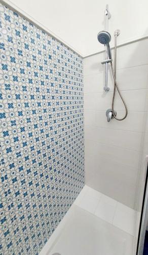 a bathroom with a shower with a tiled wall at Casa Blue Windows pt in Favignana