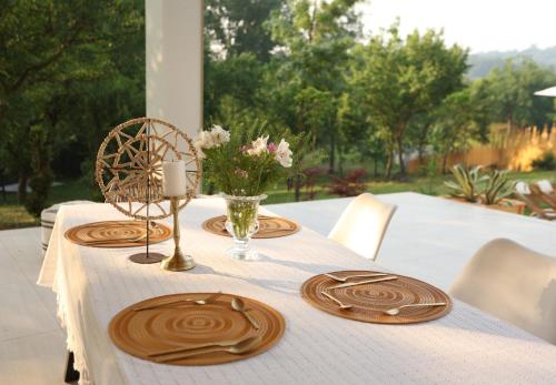 a table with a white table cloth and wooden plates on it at Kuća sa bazenom do 10 osoba Freedom Place in Jagodina
