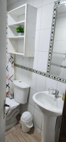 biała łazienka z toaletą i umywalką w obiekcie Cómoda y Acogedora casa climatizada w mieście Punta Arenas