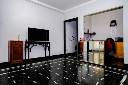 - un salon avec un sol noir et blanc et une télévision dans l'établissement Albergo Caffaro, à Gênes