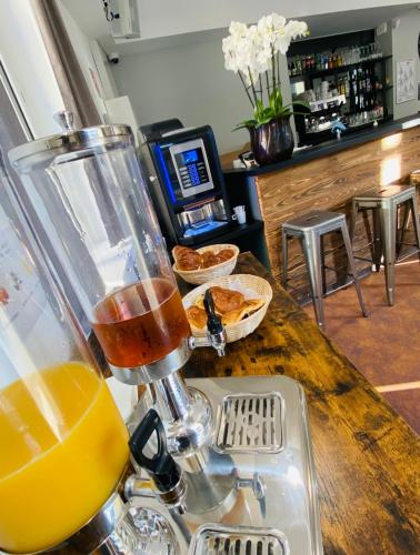 a glass of orange juice sitting on top of a counter at Hostel Flamingo Nîmes Gare Centre in Nîmes
