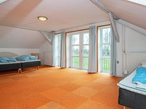OrnumにあるSix-Bedroom Holiday home in Aabenraaのベッド2台、大きな窓が備わる広い客室です。