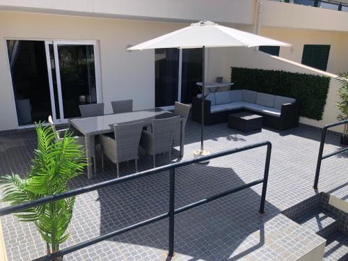 a patio with a table and chairs and an umbrella at Ocean Dream Apartment- Air Condition in Funchal