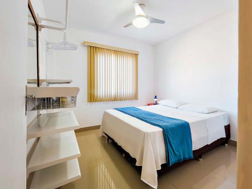 a white room with a bed and a window at Tropical Itapema in Itapema