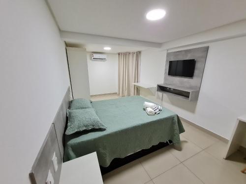 Habitación pequeña con cama y TV de pantalla plana. en Gold Flat - Miramar Hospedagens, en João Pessoa