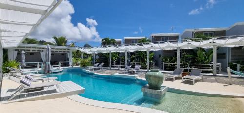 uma piscina com espreguiçadeiras e um edifício em Ocean Escape Resort & Spa em Rarotonga