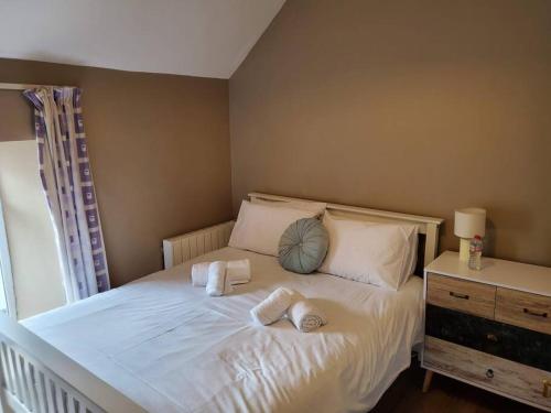 Un dormitorio con una cama blanca con toallas. en Apt. 2 - Town Centre Apartment en Bagenalstown