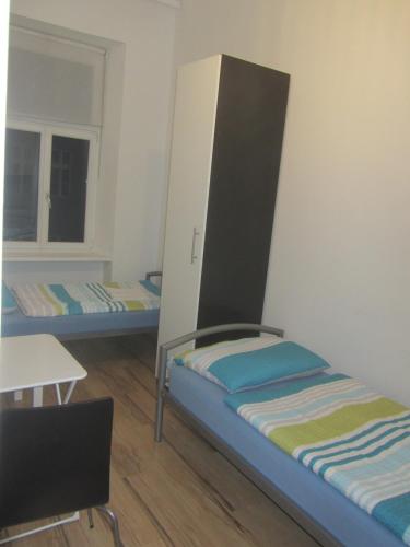 Pokój z 2 łóżkami, stołem i biurkiem w obiekcie Apartments Johann w Wiedniu