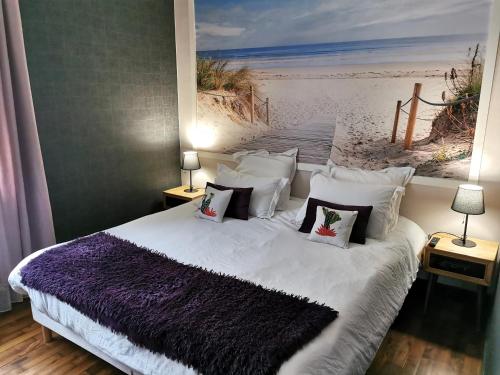 1 dormitorio con 1 cama y una pintura de playa en PORT-ROUSSE - La Rouliere, en Les Sables-dʼOlonne