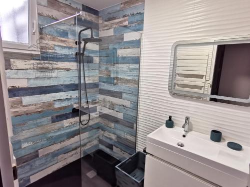 Un baño con ducha y lavabo blanco. en PORT-ROUSSE - La Rouliere, en Les Sables-dʼOlonne
