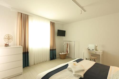 a white bedroom with a bed and a desk at Kuća sa bazenom do 10 osoba Freedom Place in Jagodina