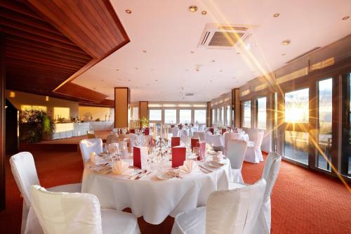 a banquet hall with white tables and white chairs at Hotel Stadt Breisach in Breisach am Rhein