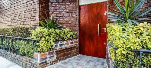 a red door in a brick building with plants at Habitación con baño privado A, Centro de Coyoacán in Mexico City