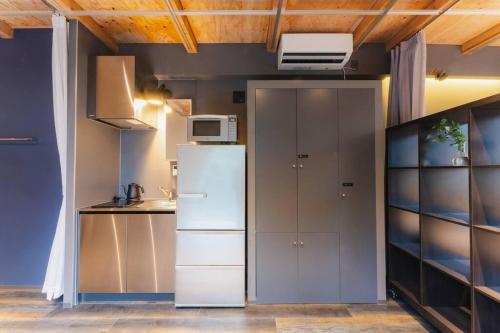 a kitchen with a refrigerator and a microwave at Corent代田橋 in Tokyo