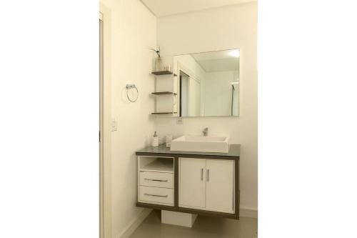 een badkamer met een wastafel en een spiegel bij Supremo in Meia Praia