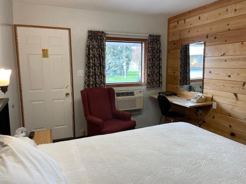 een slaapkamer met een bed, een bureau en een stoel bij Walla Walla Garden Motel in Walla Walla