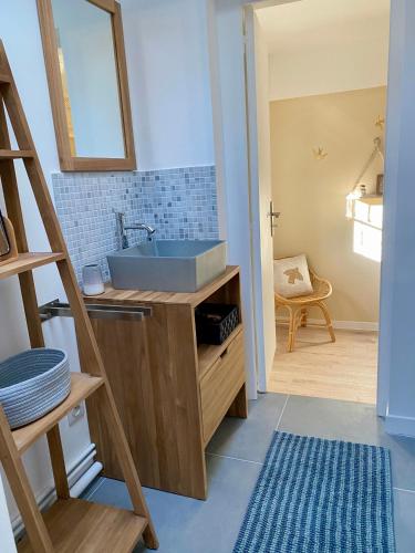 La salle de bains est pourvue d'un lavabo bleu et d'une échelle. dans l'établissement La Casa de la Mouette Rieuse, à Eu