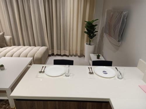 luxury studio in Casablanca في الدار البيضاء: غرفة معيشة مع طاولة بيضاء وأريكة