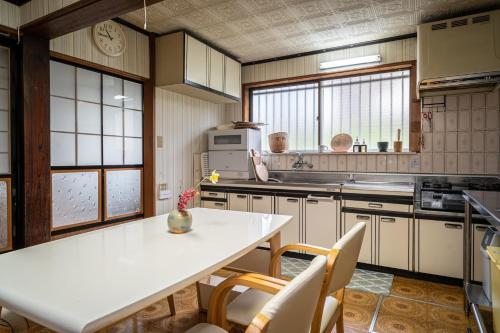 ojirotomarlo : مطبخ مع طاولة بيضاء وكراسي