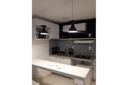 een keuken met witte kasten en een wit aanrecht bij Laguna Beach Porto de Galinhas in Camela