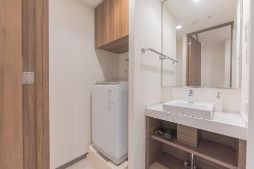 Un baño blanco con lavabo y espejo. en i-rent京急蒲田, en Tokio
