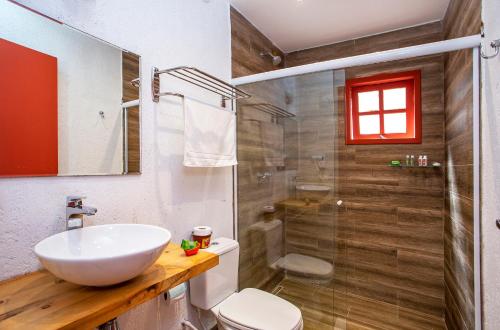y baño con lavabo, aseo y ducha. en Pousada Vila Suiça - Monte Verde, en Monte Verde