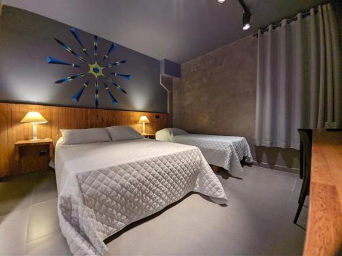 ein Schlafzimmer mit 2 Betten und einer Uhr an der Wand in der Unterkunft Villa'l Mare Hotel in Maresias
