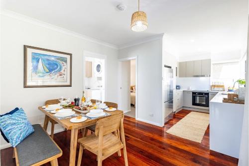 a kitchen and living room with a table and chairs at Banksia at Fingal 1 92 Rocky Point Rd Aircon spa and Wi Fi in Fingal Bay