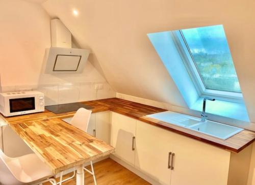 une petite cuisine avec un évier et une fenêtre dans l'établissement Appartement rénové proche Gare, à Quimper