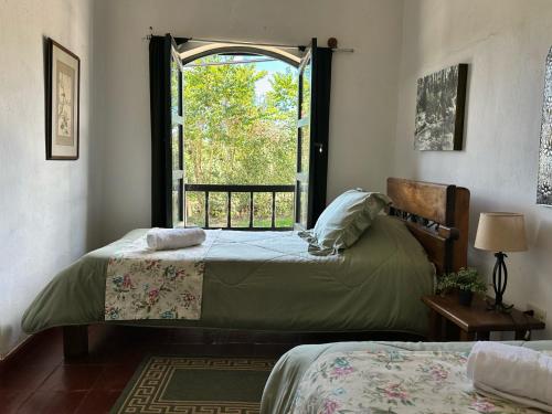 een slaapkamer met 2 bedden en een raam bij Casa Tirteo ( A 500 m de la plaza principal) in Villa de Leyva