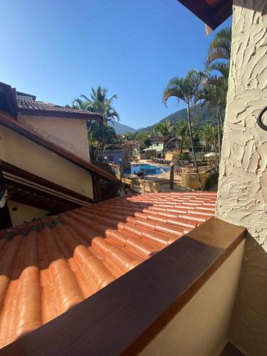 an orange tile roof on a building with palm trees at Villa'l Mare Hotel in Maresias