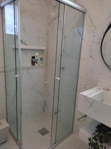 eine Dusche mit Glastür im Badezimmer in der Unterkunft Apartamento na Praia da Enseada, 100 mt praia in São Francisco do Sul