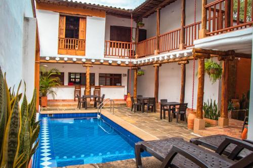 dom z basenem, stołami i krzesłami w obiekcie Hotel Tierra Roja By MH w mieście Barichara