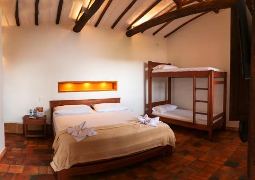 um quarto com 2 beliches e uma escada em Hotel Tierra Roja By MH em Barichara