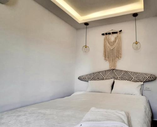 a white bedroom with a bed and two lights at Luxurious and cosy studio in Abidjan