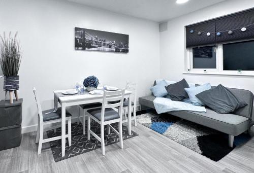 Enfield Lock的住宿－Cosy Contemporary Apartment - Brimsdown, Enfield，客厅配有桌子和沙发