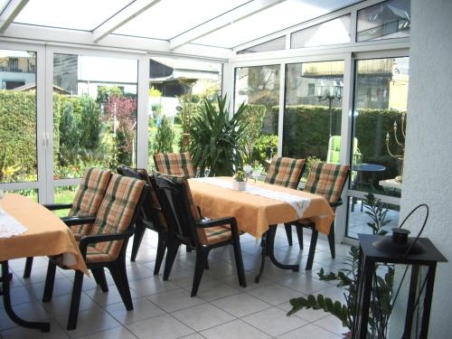 a conservatory with a table and chairs on a patio at Gästehaus Resi in Zeltingen-Rachtig
