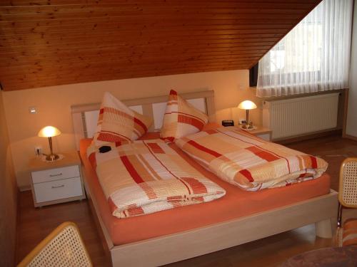 ツェルティンゲン・ラハティグにあるGästehaus Resiのベッドルーム1室(ストライプ枕付きベッド2台付)