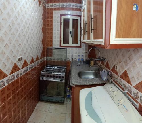 a small kitchen with a sink and a stove at Furnished Apartment - Beach view "Nearest Beach 2 minutes walking" - Free Wifi- Abo keer - Alexandria - Egypt in Abū Qīr