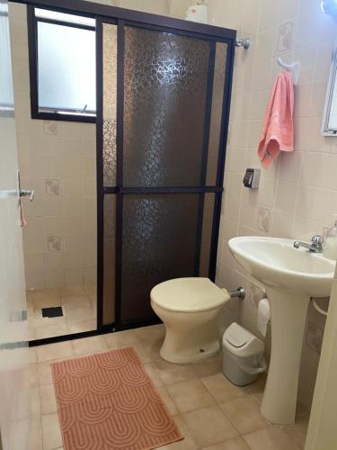 a bathroom with a shower and a toilet and a sink at Apartamento aluguel temporada diária Praia Grande AVIAÇÃO BEIRA MAR in Praia Grande