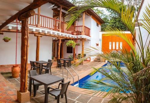 Hotel Tierra Roja By MH في باريكارا: فناء به طاولات وكراسي بجانب مسبح